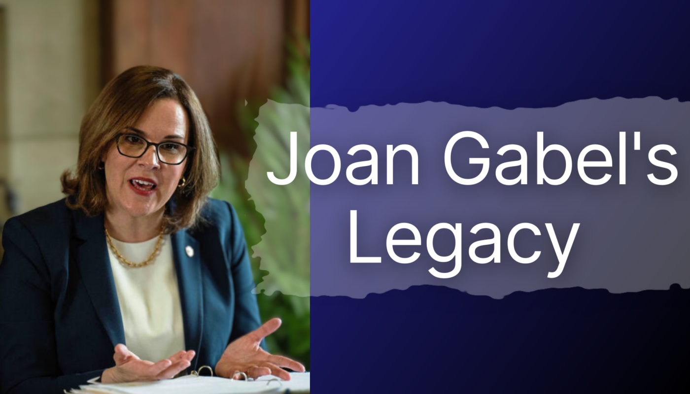 Joan Gabel talking into a microphone at desk, with words saying Joan Gabel's Legacy